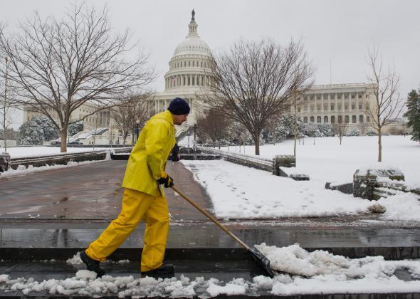 479264749-worker-shovels-snow-from-the-walkways-at-the-us-capitol