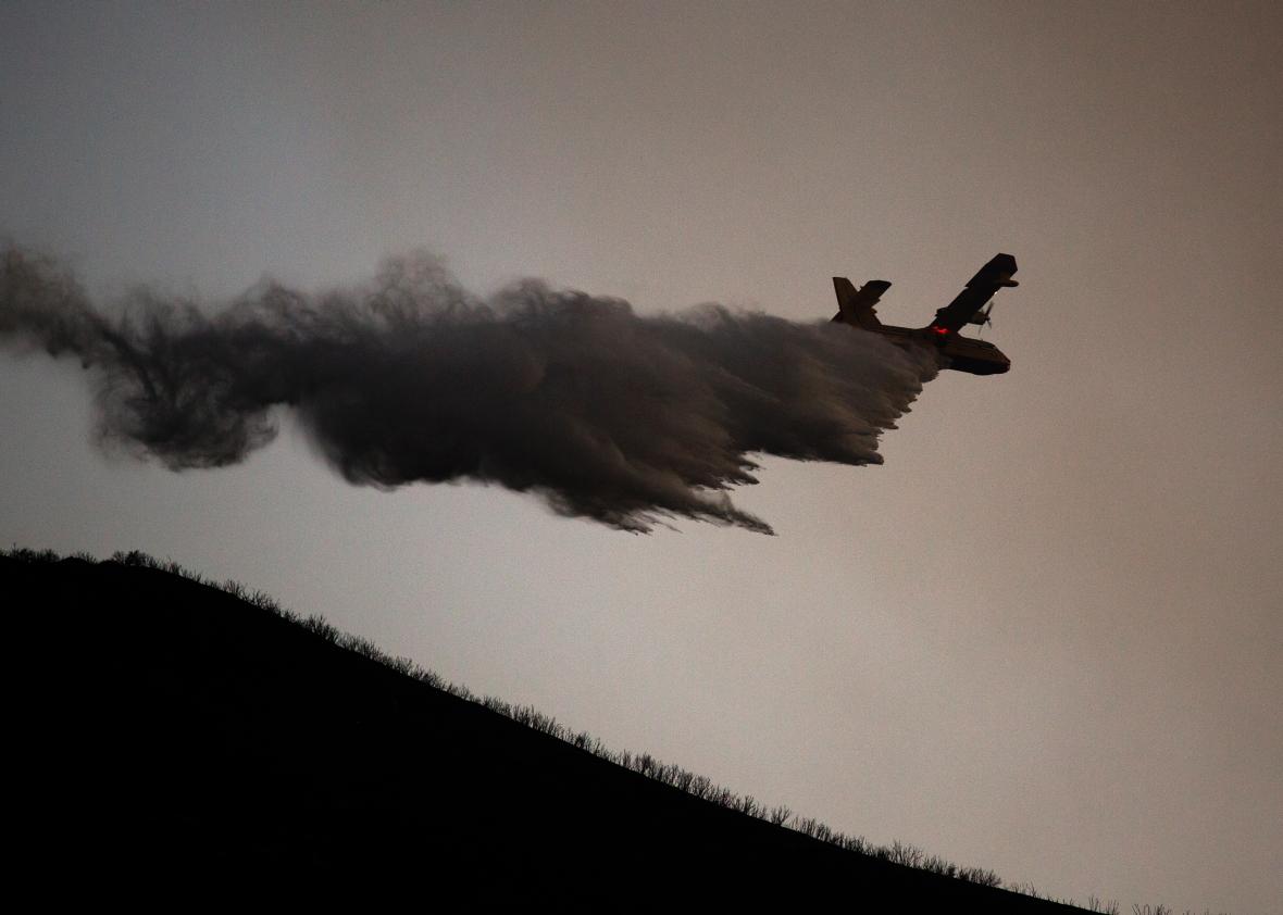 A firefighting aircraft drops water on Aug. 16, 2015 in the Angeles National Forest north of Castaic, California.