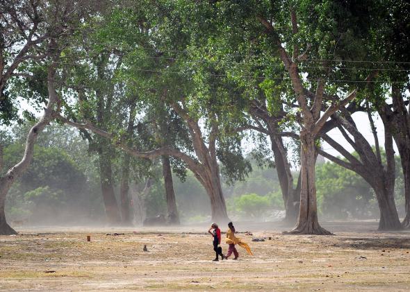 474375758-indian-girls-walk-home-during-a-hot-summer-day-in