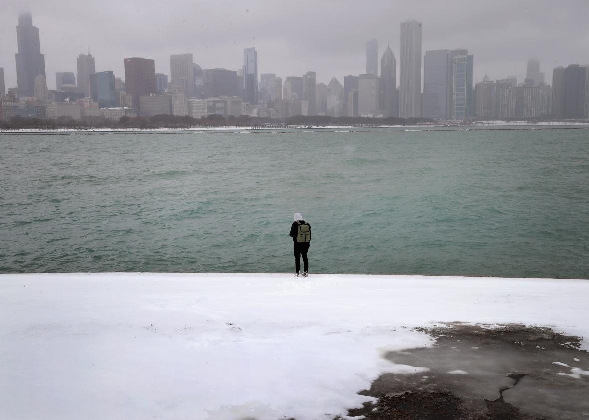 653016584-visitor-photographs-the-skyline-from-the-shore-of-lake