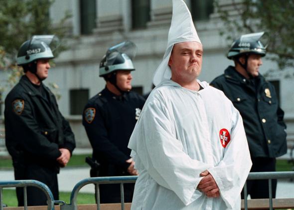 152898655-ku-klux-klan-member-stands-with-heavy-police-protection 152898655-ku-klux-klan-member-stands-with-heavy-police-protection